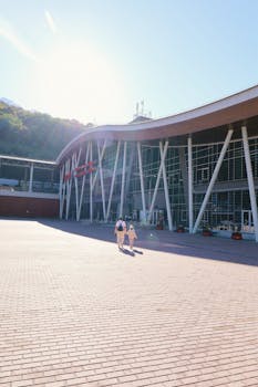 Contemporary architecture with sunlit courtyard and walking couple.