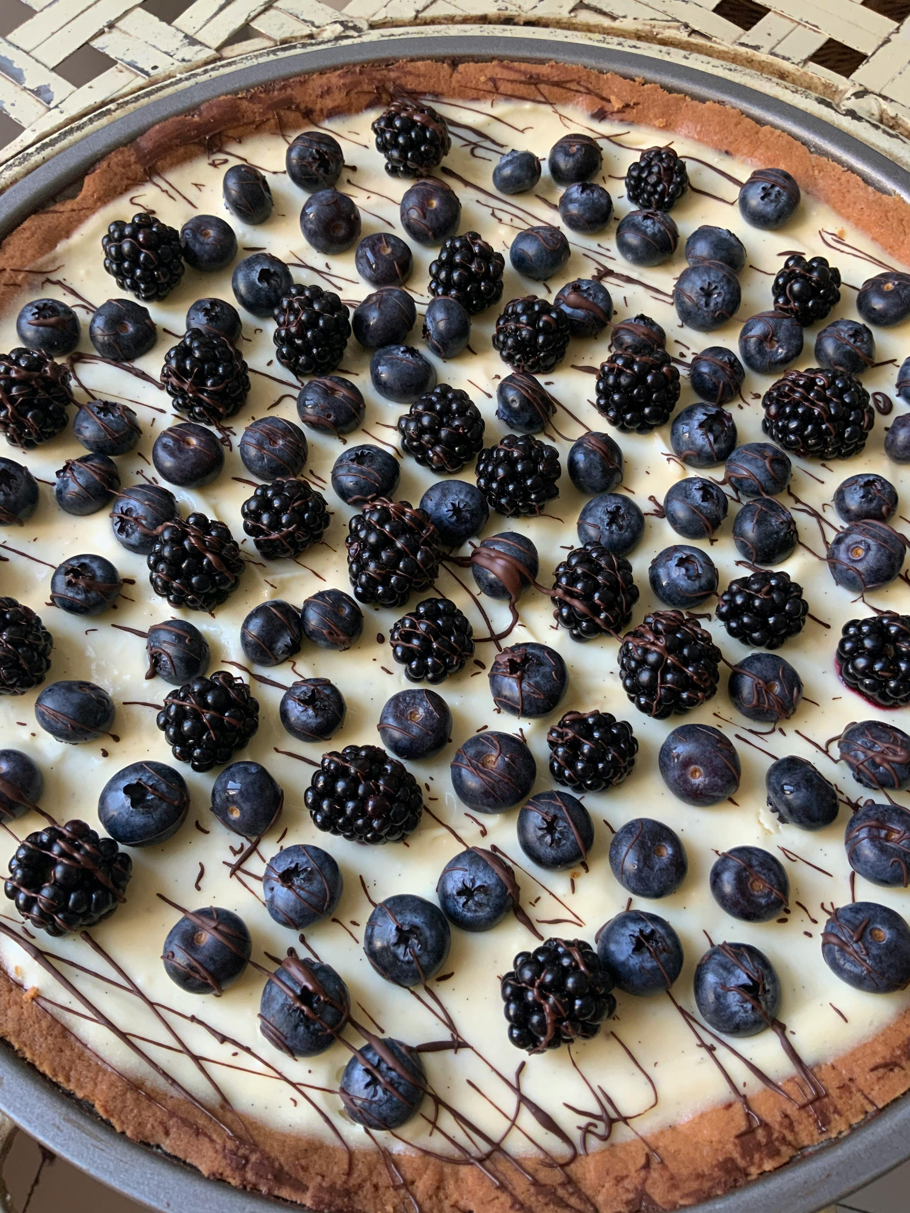 Baked muscadine cobbler in a rustic pan with a serving spoon