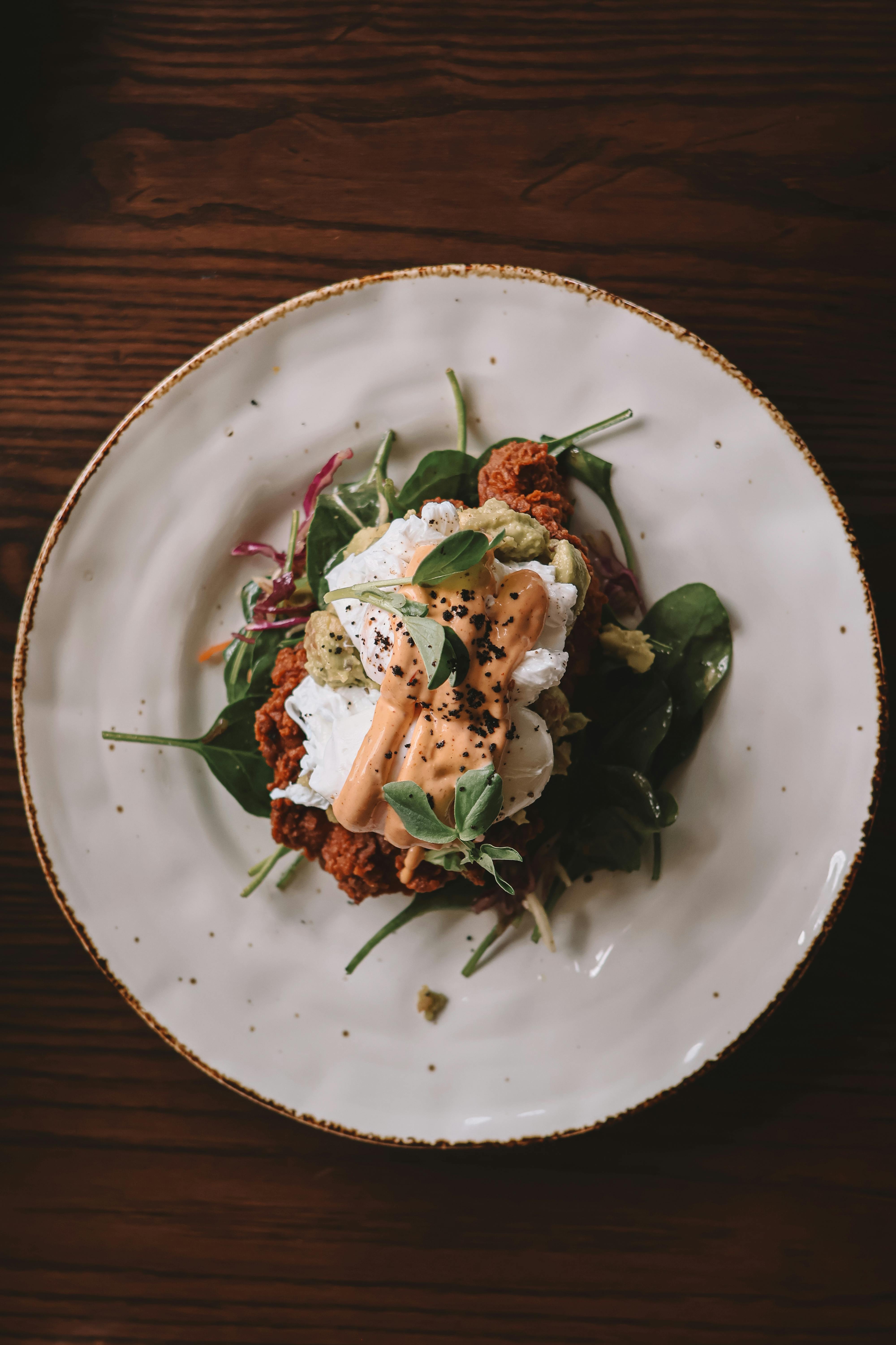 gourmet poached egg salad on rustic table