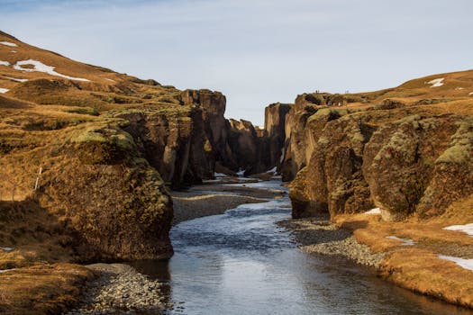 Scenic view of a dramatic canyon with a winding river on a remote island under a clear sky.