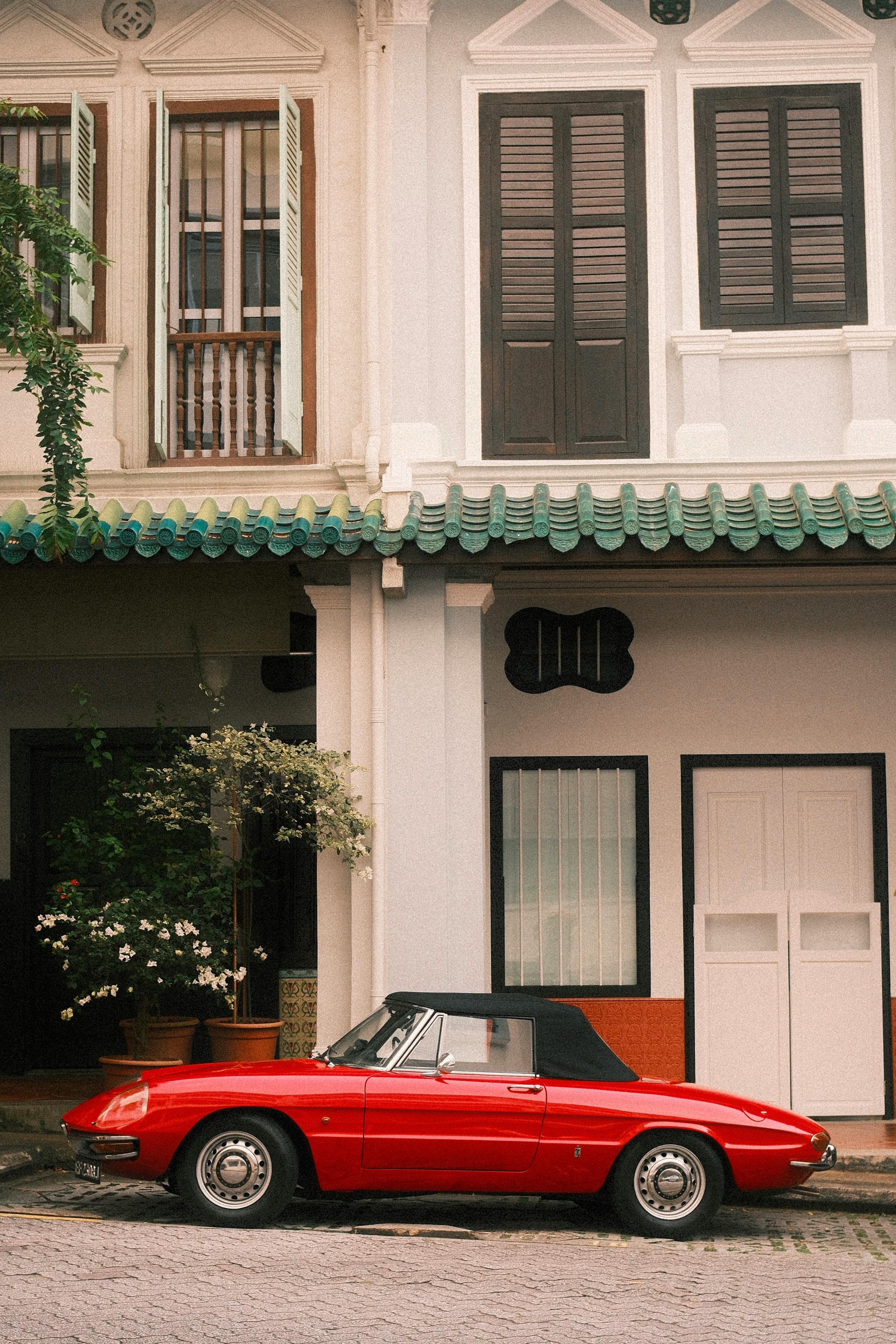 classic red convertible parked by heritage building