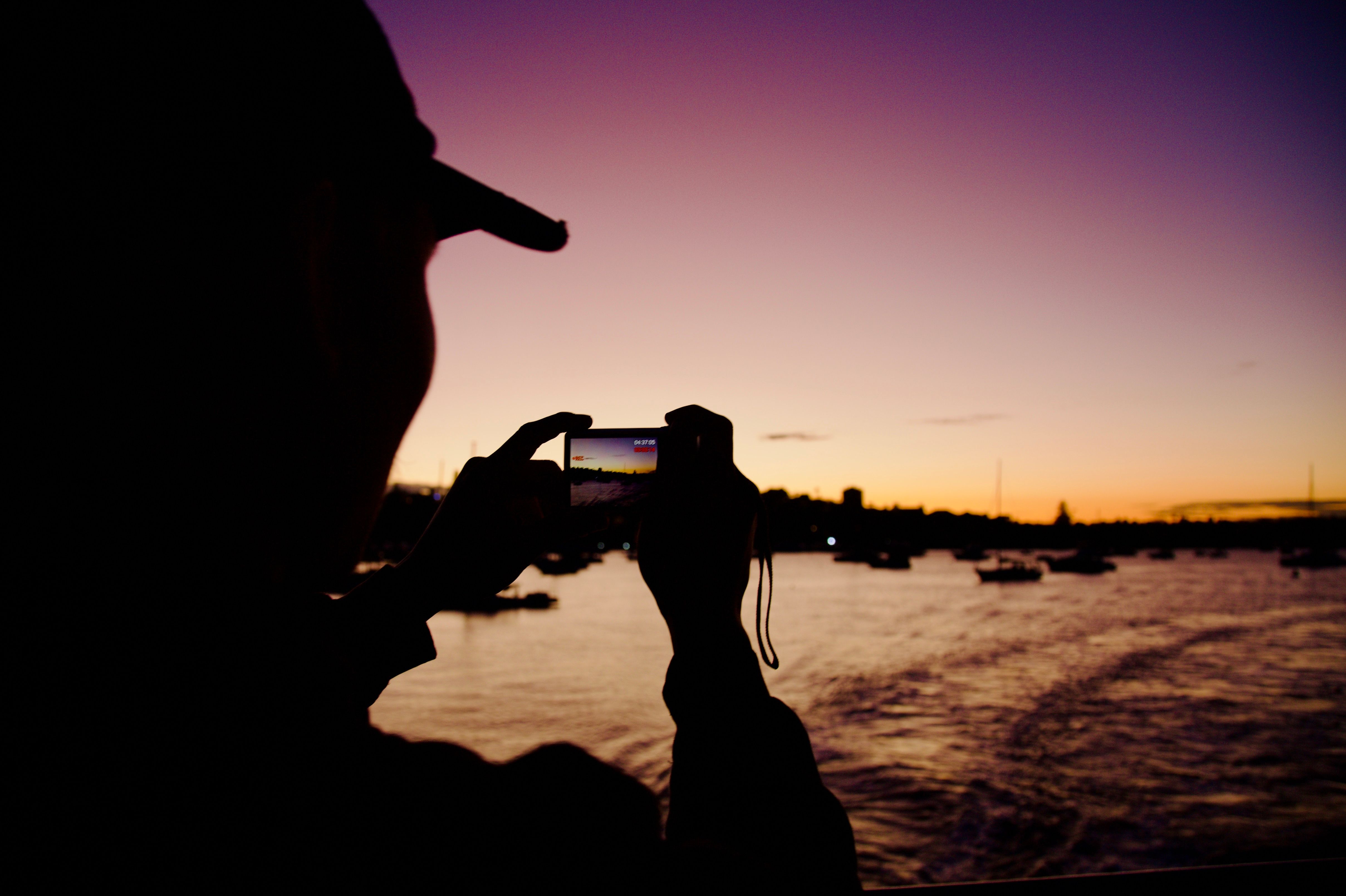 Fotomural Una persona toma una foto de un impresionante atardecer en The Rocks, Sydney.