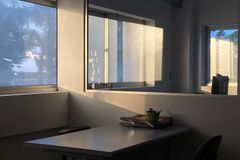 A serene office space with evening sunlight casting shadows through windows.