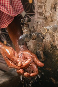 Close-up of hands washing under a tap in Jalandhar, India, conveying hygiene and daily life.