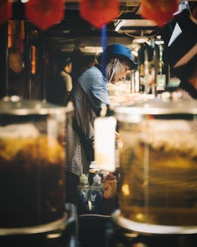 A focused street vendor preparing food in a vibrant night market setting.