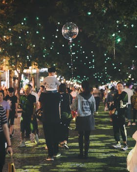 夜晚，人们在热闹的街头节日中点亮并欣赏着串灯