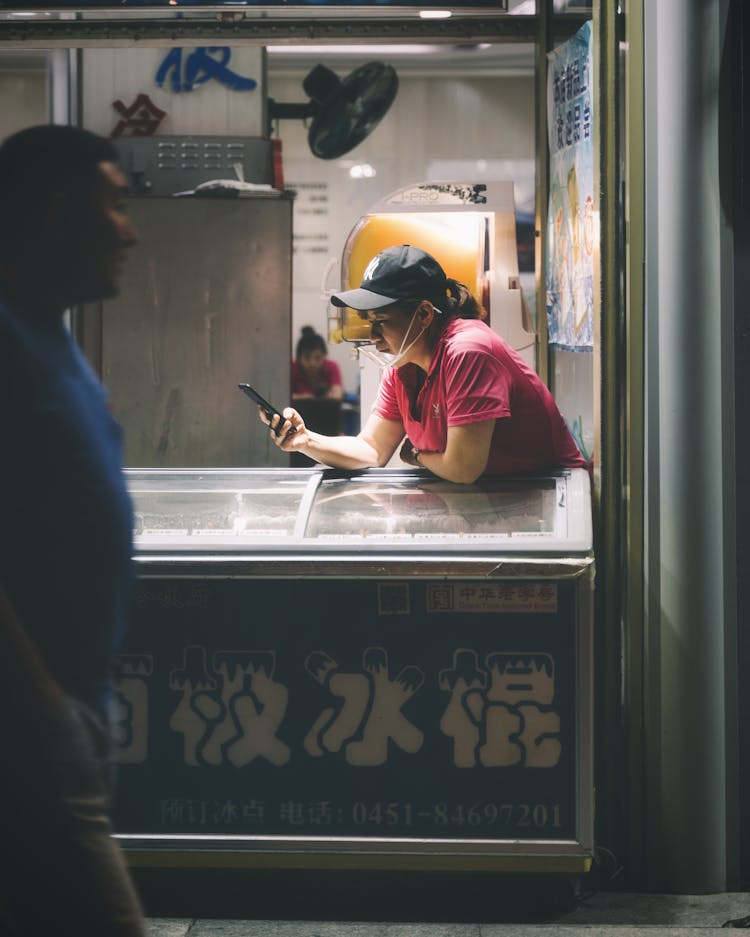 Man Walking In Street Near Woman Leaning On Ice Cream Refrigerator