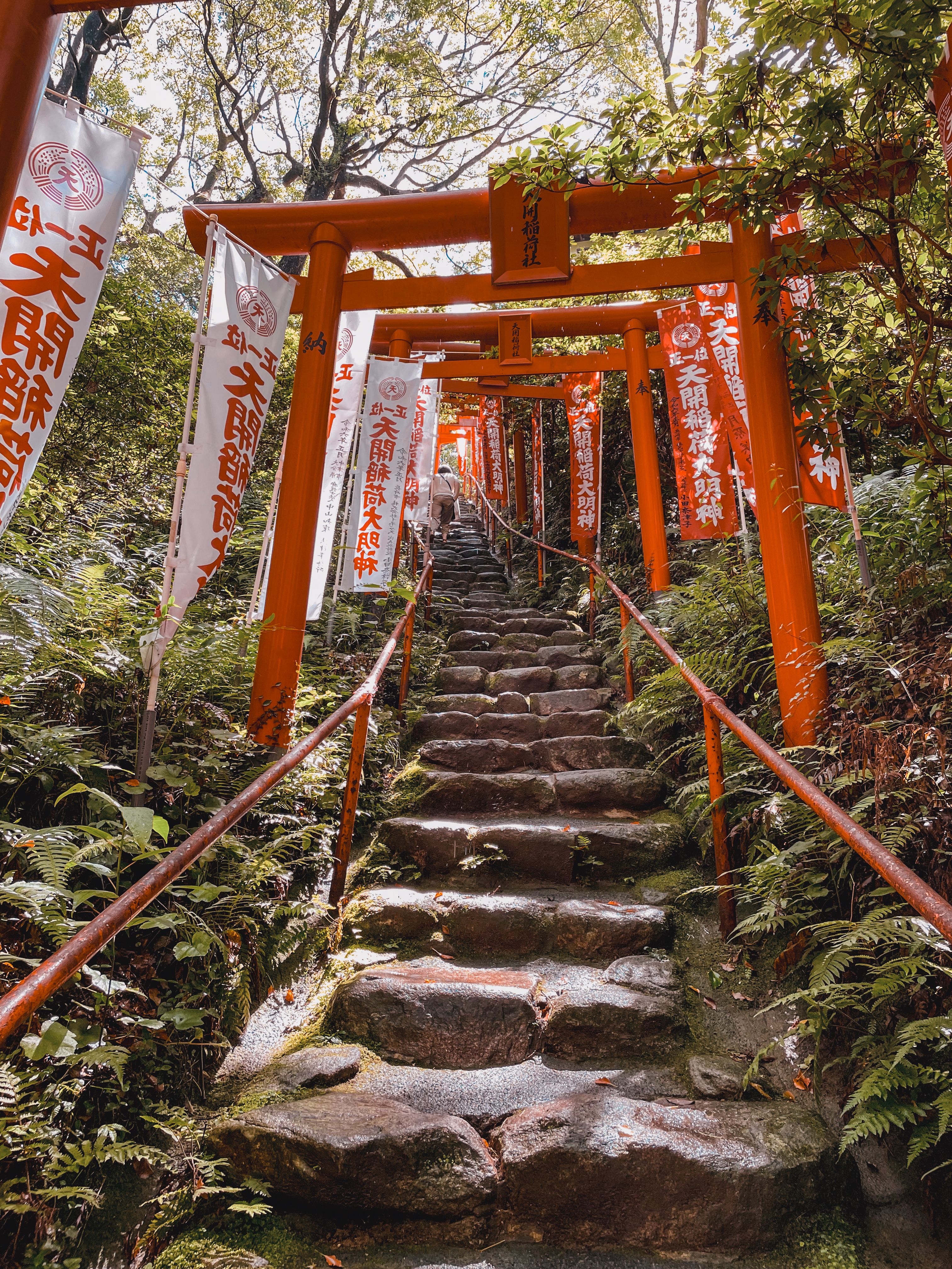 Red torii gates on stone staircase at a traditional shrine in Fukuoka, Japan