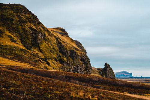 Free Explore rugged Icelandic landscape with hills and ocean view. Stock Photo