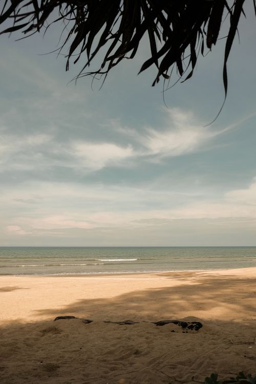 Free A serene beach scene with gentle waves under a clear sky, offering a peaceful escape. Stock Photo