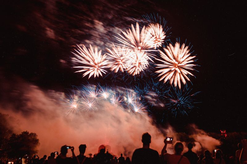 Crowd of spectators watching a fireworks display at night