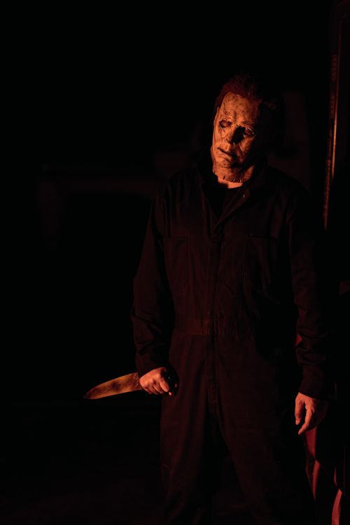 Free A mysterious masked figure stands with a knife in a dimly lit, eerie environment. Stock Photo