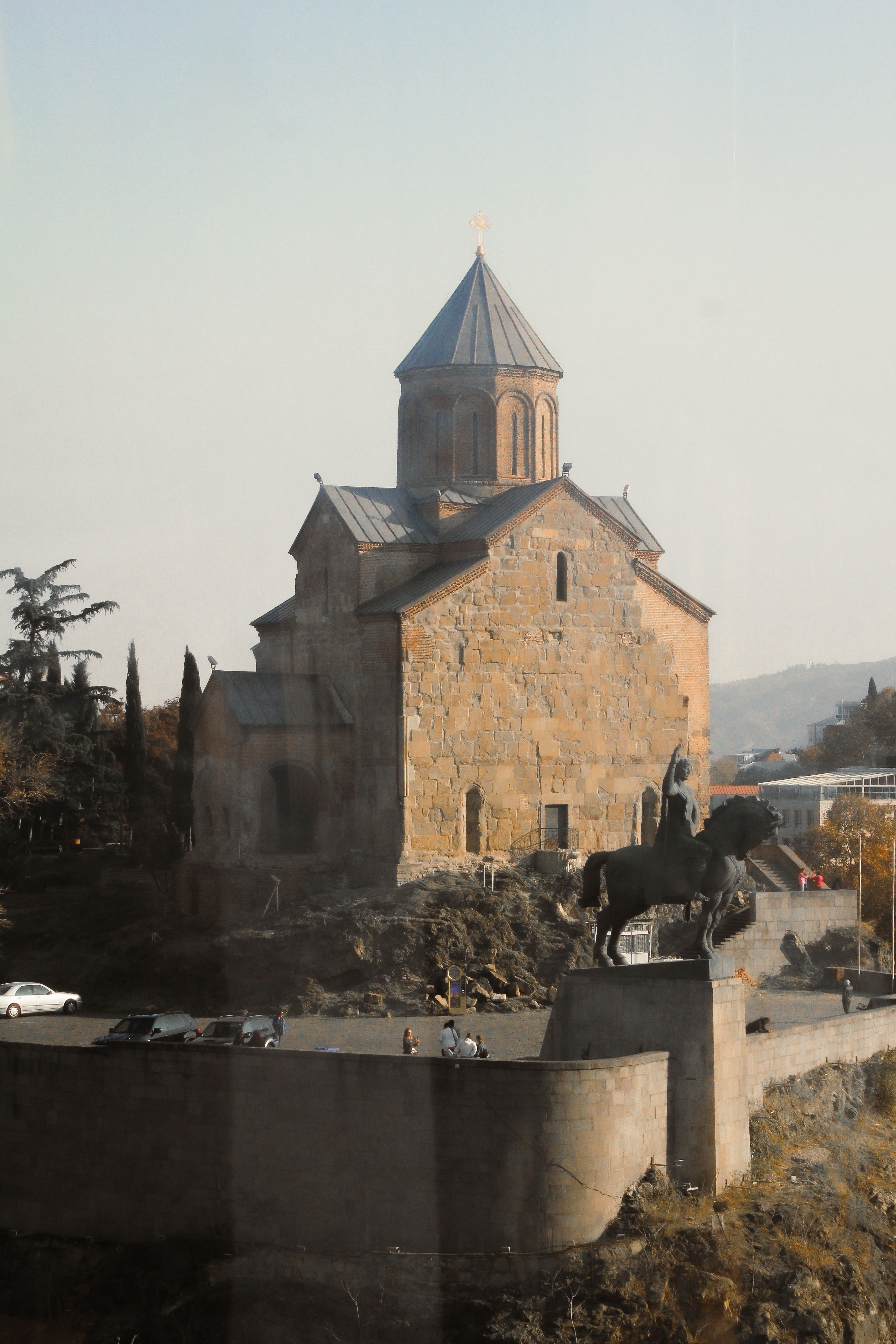 Historic Metekhi Church and equestrian statue in Tbilisi, Georgia during fall.