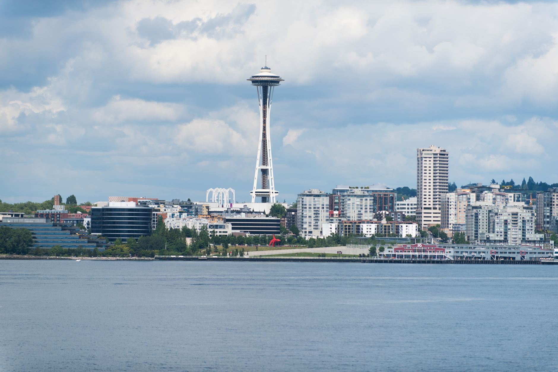 A scenic view of the Seattle skyline featuring the iconic Space Needle against a cloudy sky.