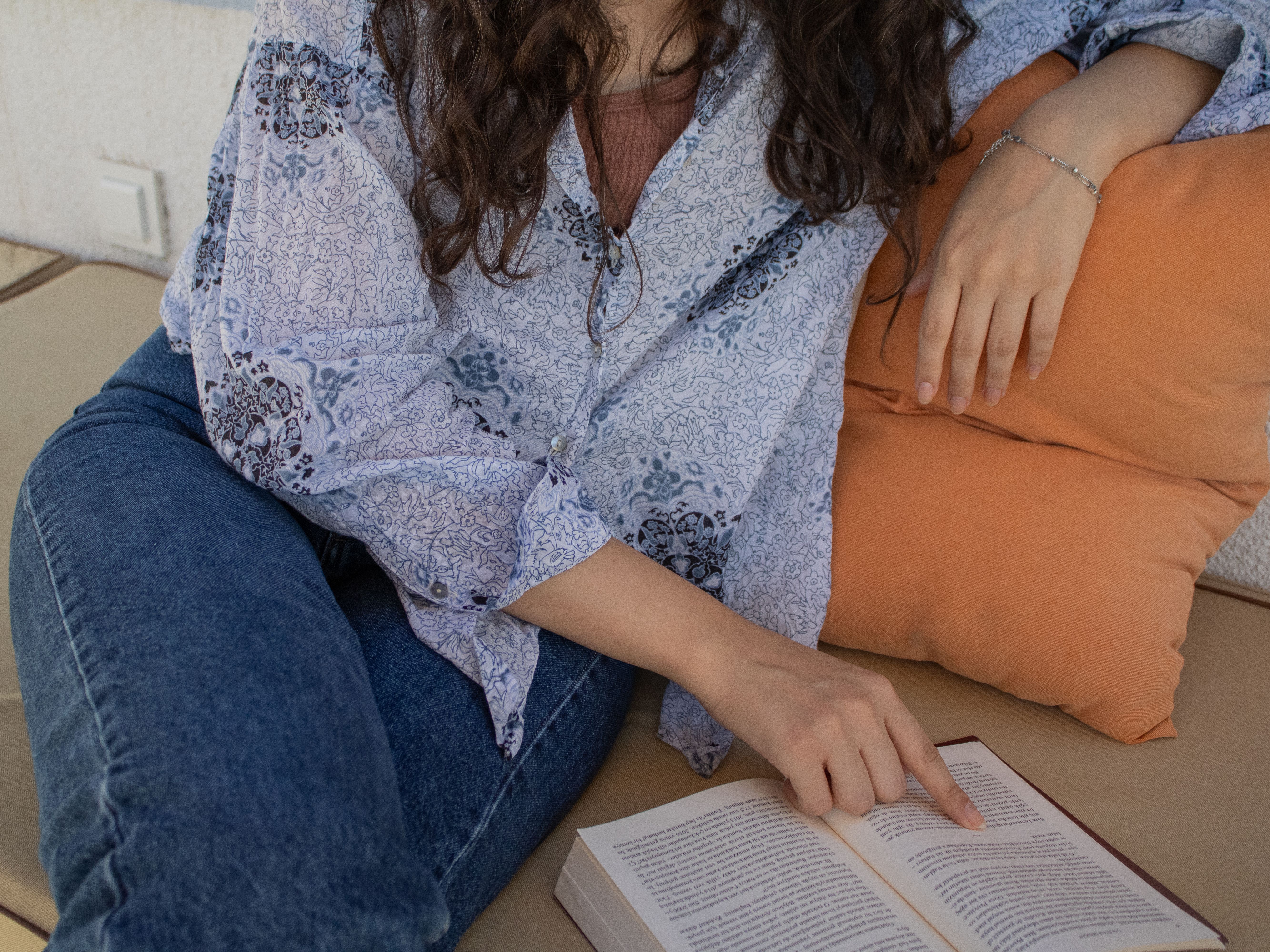 Young Woman Reading a Book in Cozy Setting · Free Stock Photo