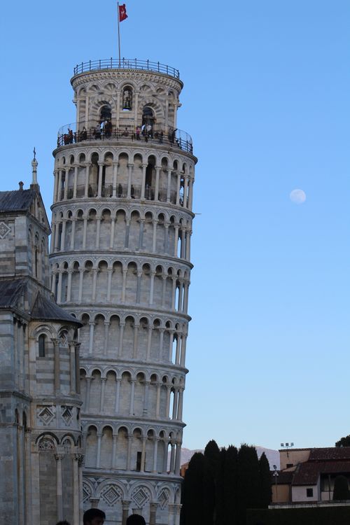 Free Capture of the Leaning Tower of Pisa as the moon rises in the evening sky. Stock Photo