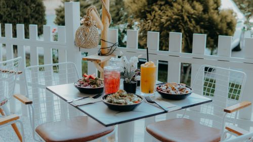 Free Charming outdoor dining setup with fresh salads and vibrant drinks on a patio table. Stock Photo