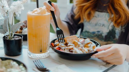 Free A close-up of a delicious dessert and icy orange smoothie enjoyed indoors, perfect for summer. Stock Photo