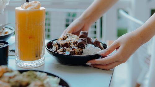 Free Appetizing dessert with whipped cream and orange juice on a table outdoors. Stock Photo