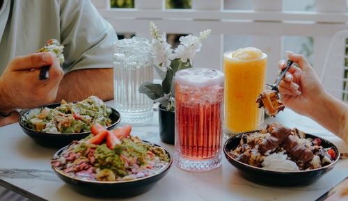 Free Enjoy a refreshing outdoor brunch featuring colorful smoothie bowls and fresh drinks. Stock Photo