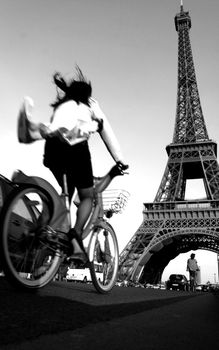 A dynamic shot of a cyclist near the iconic Eiffel Tower in Paris.