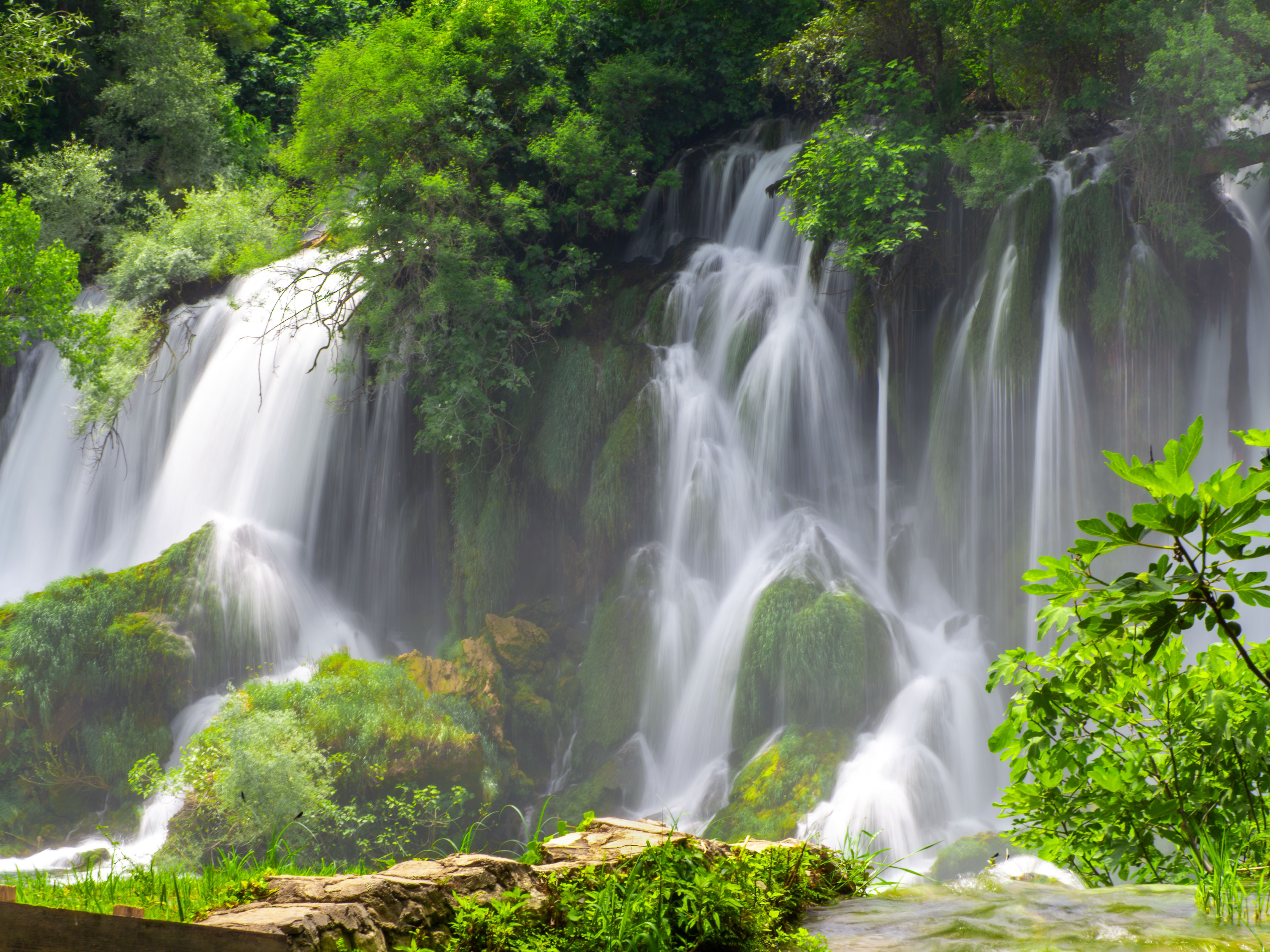 A picturesque waterfall cascades amidst lush greenery in Bosnia and Herzegovina.