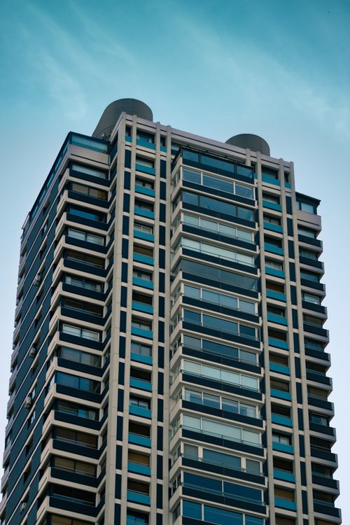 Free A towering skyscraper with modern architecture against a clear blue sky. Stock Photo