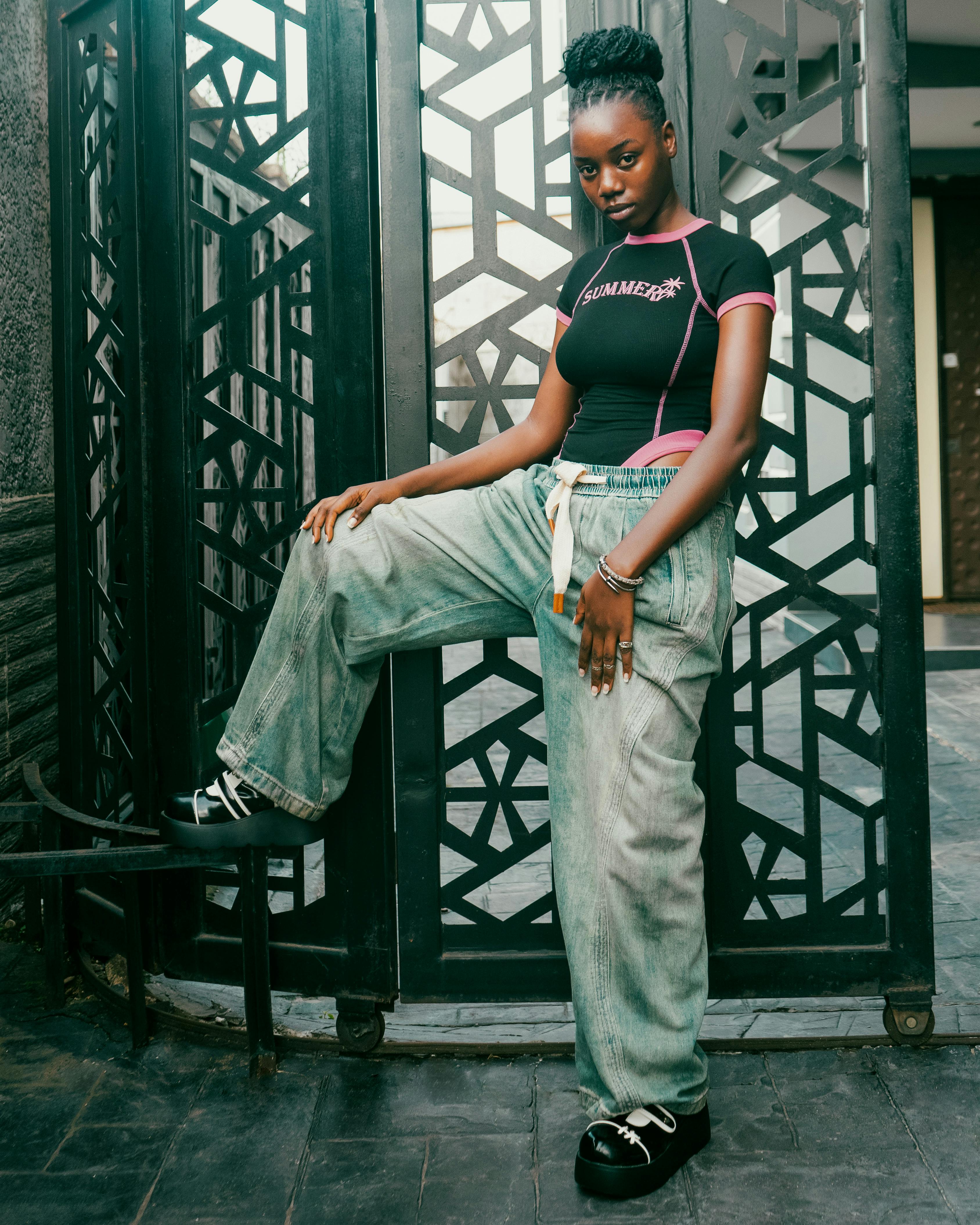Young woman exuding confidence in trendy urban streetwear posing outdoors.
