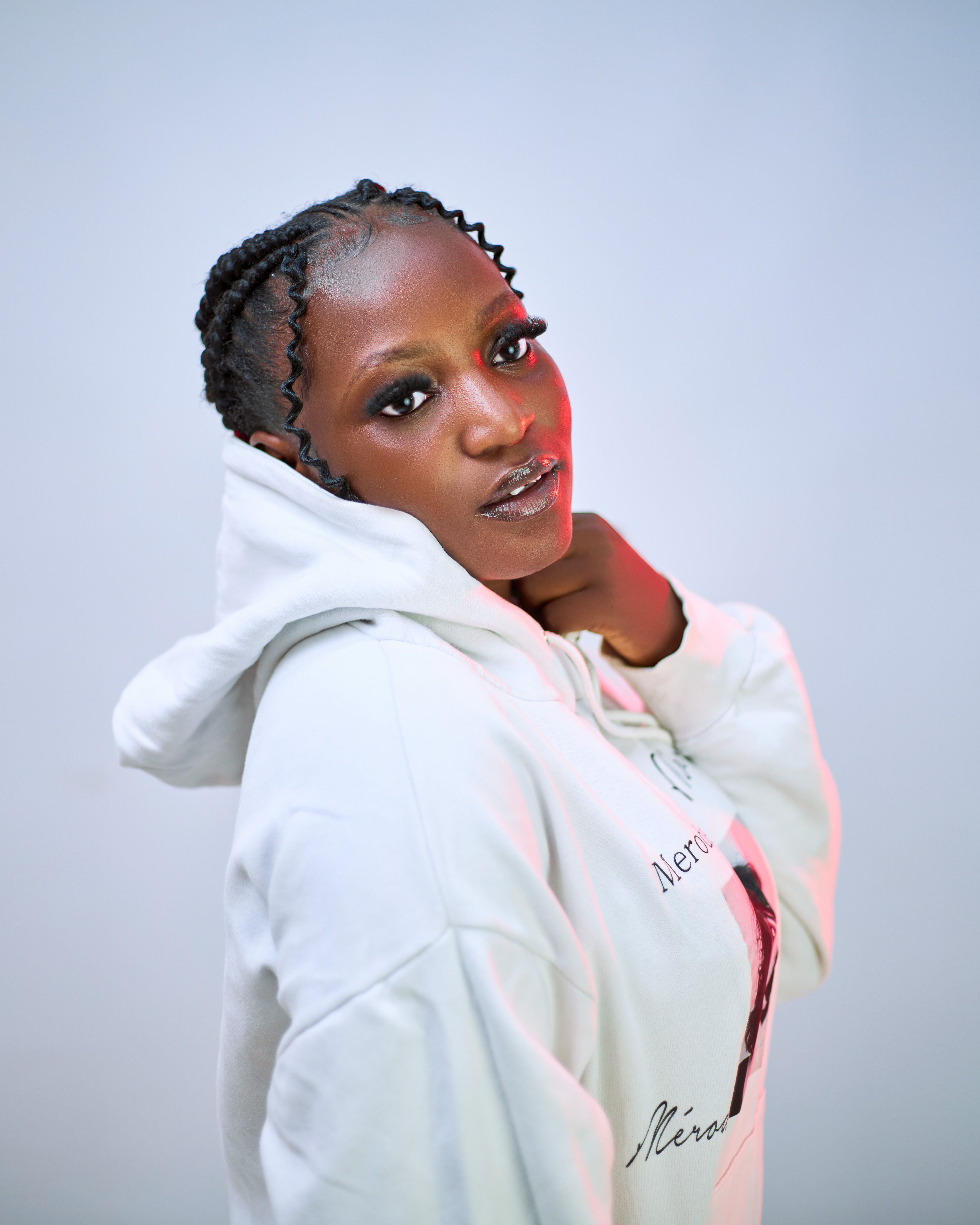 Captivating portrait of a woman in a white hoodie, modern street style.