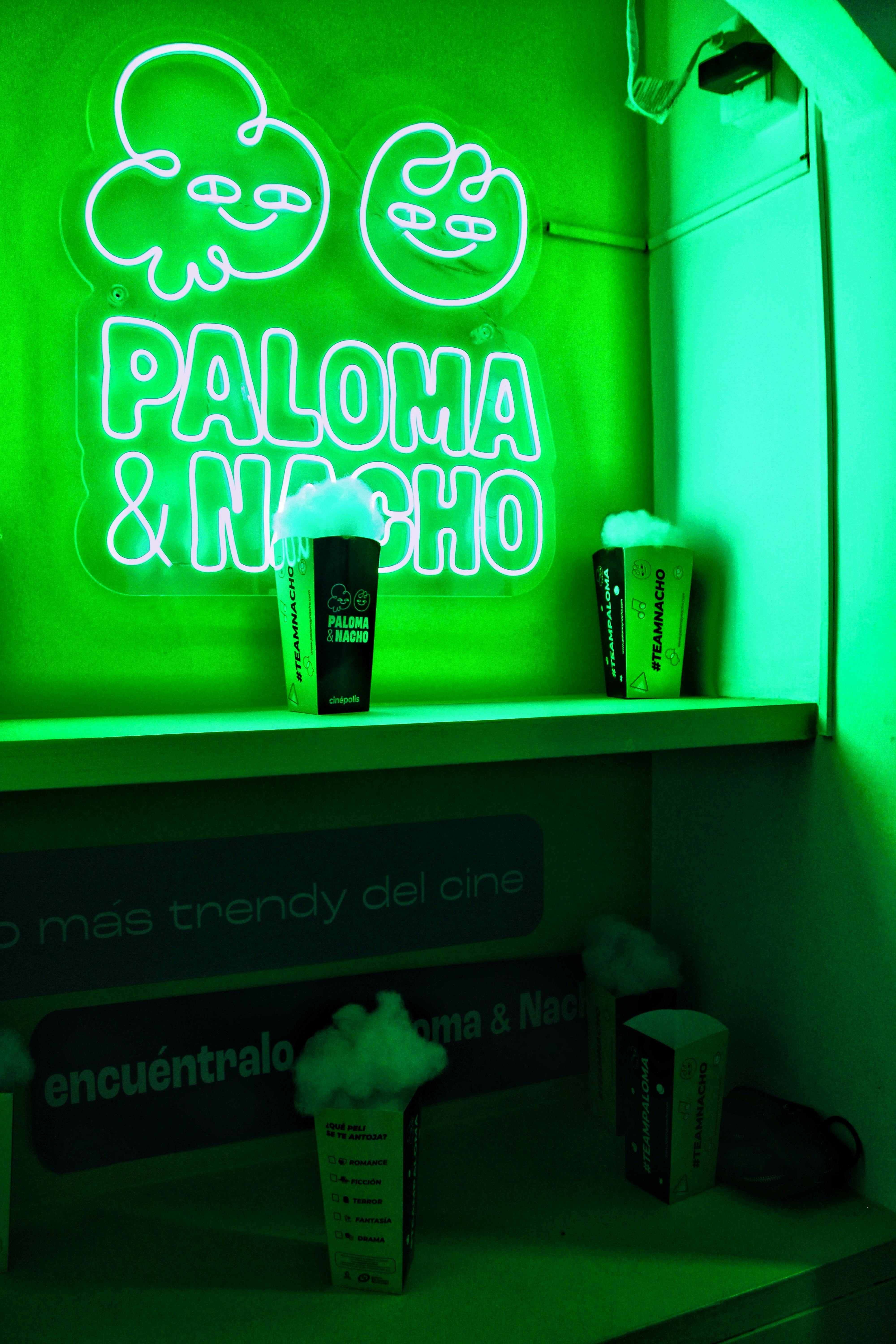 Free Vibrant green neon sign with popcorn cups on shelves. Trendy and artistic. Stock Photo