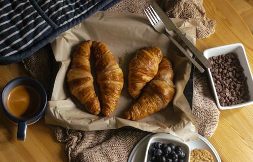Free Freshly baked croissants with chocolate chips and coffee, perfect for breakfast. Stock Photo