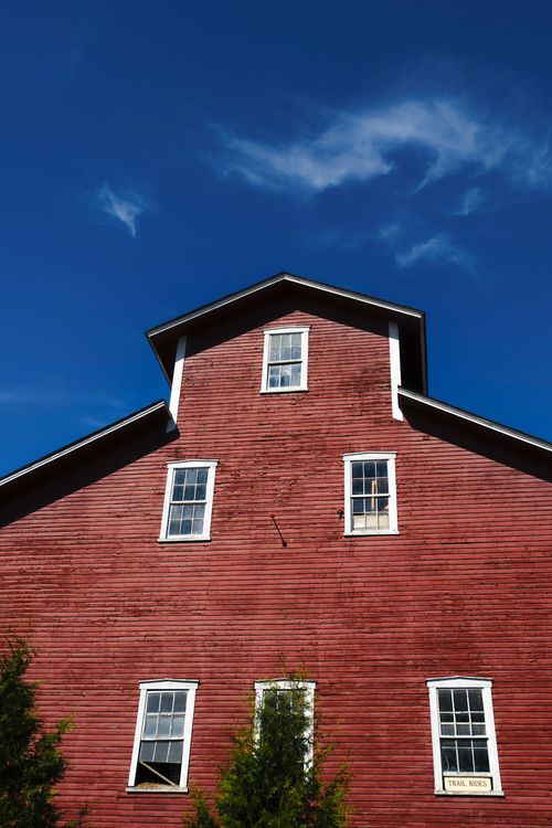 Free Striking red barn under a vibrant blue sky, showcasing classic rural architecture. Stock Photo