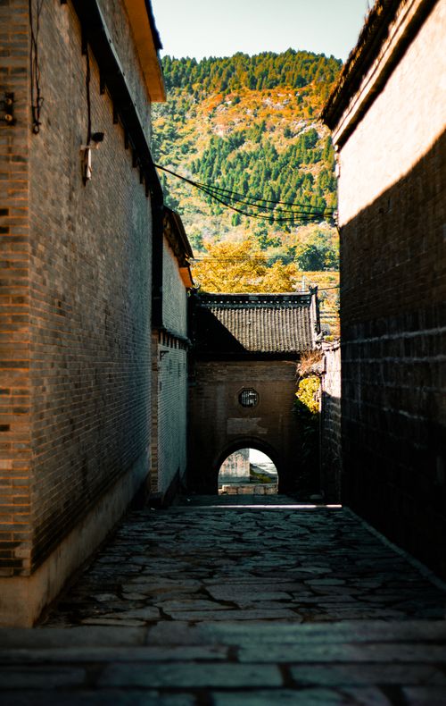 Free Beautiful alleyway with traditional architecture and scenic hillside in the background, captured in daylight. Stock Photo