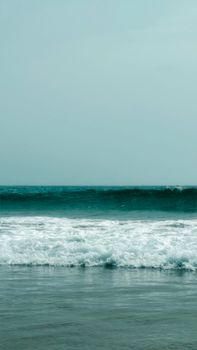 Peaceful seascape with gentle ocean waves on a serene beach during daytime.