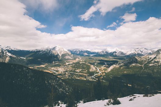 Breathtaking aerial view of a snow-capped mountain range with lush valleys below.