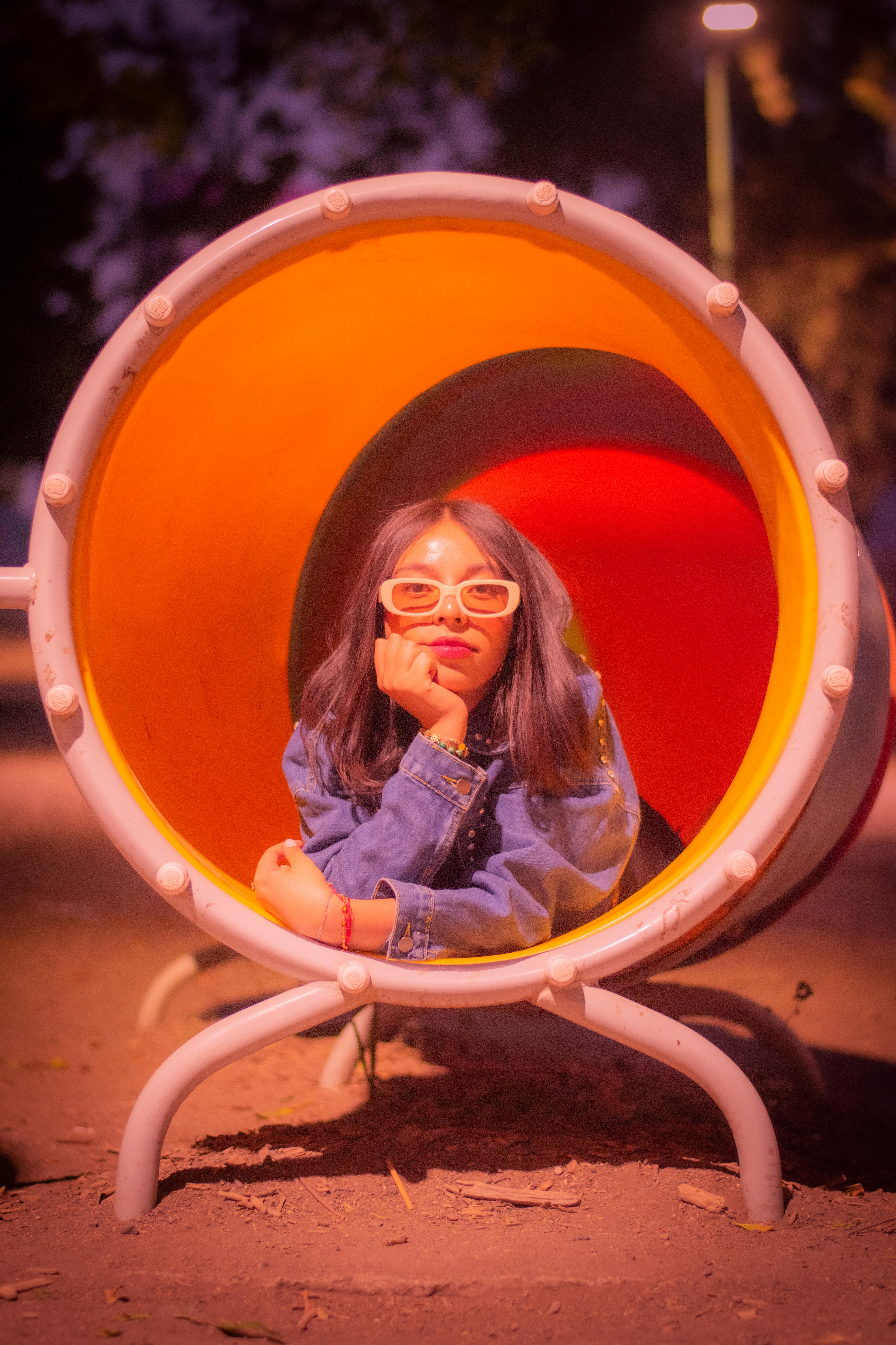 girl in colorful playground tunnel at night