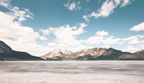 бесплатная Белая коричневая гора под белым облаком и голубым небом в дневное время Стоковое фото