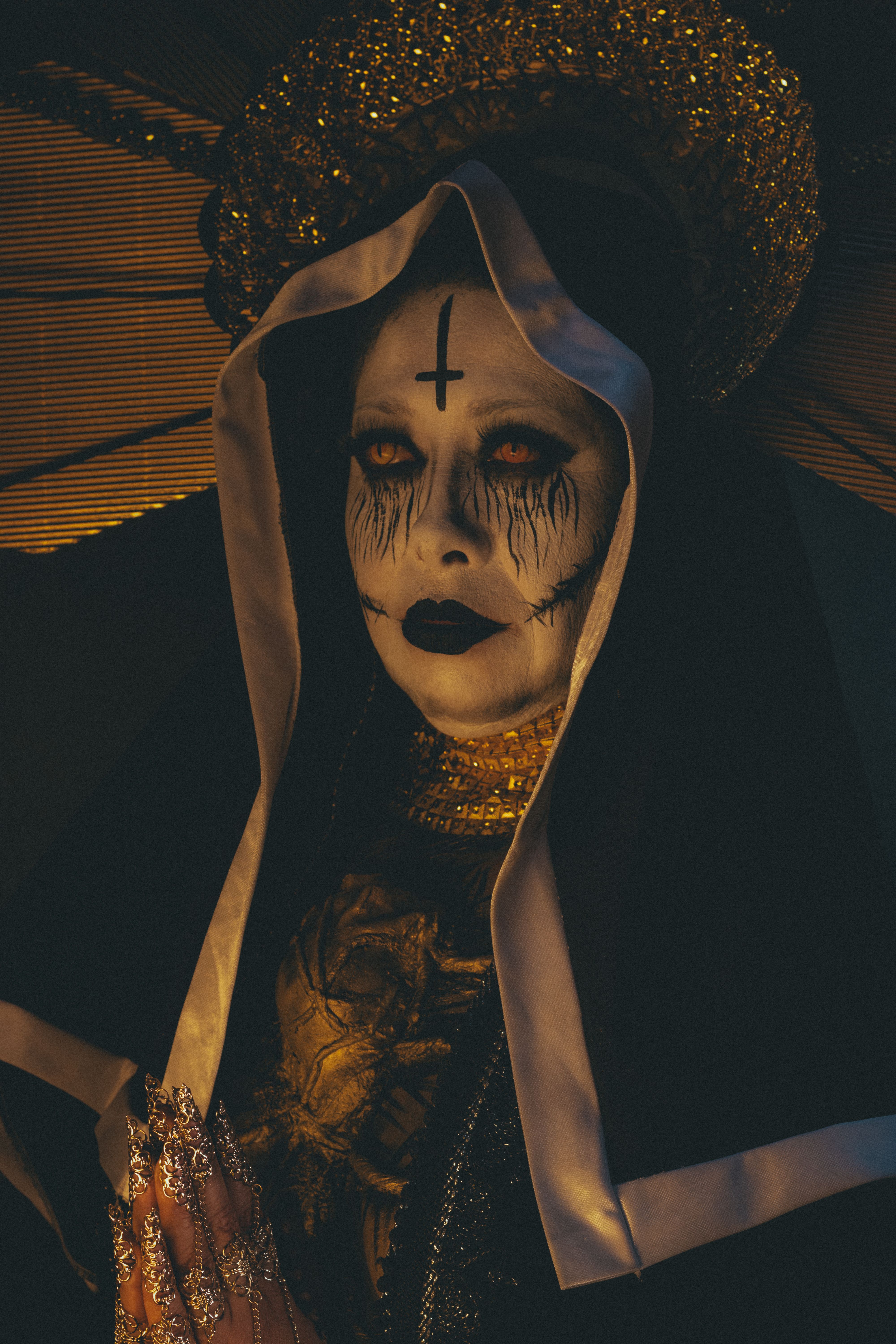 Eerie portrait of a nun with gothic makeup and dark religious symbolism.