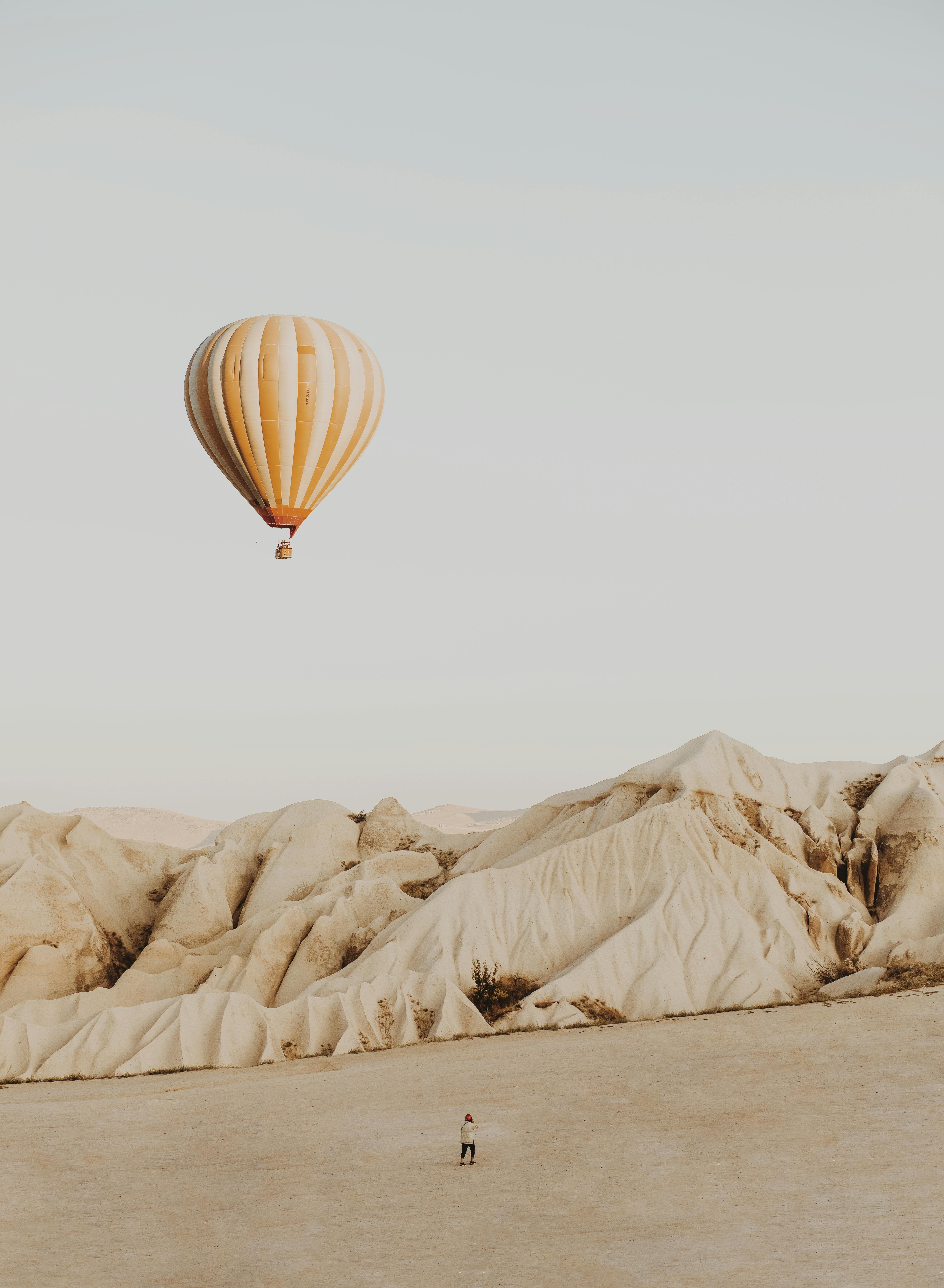Person Standing on Desert Front of Hot Air Balloon