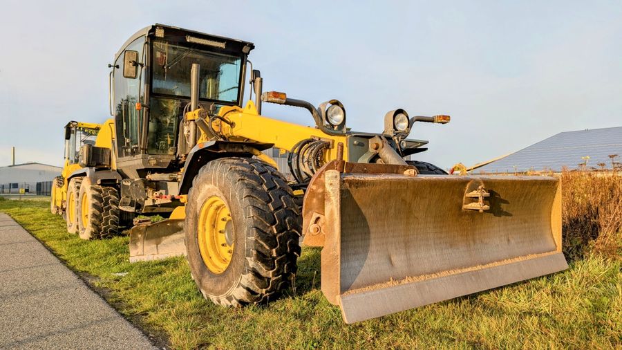 DX-G705 Power Grader, yellow motor grader parked on grass