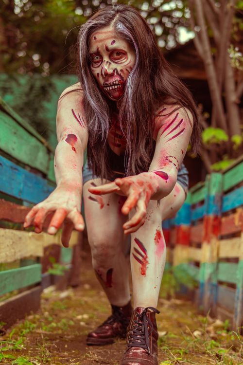 Free A realistic zombie cosplay with detailed makeup in an outdoor setting, ideal for Halloween inspiration. Stock Photo