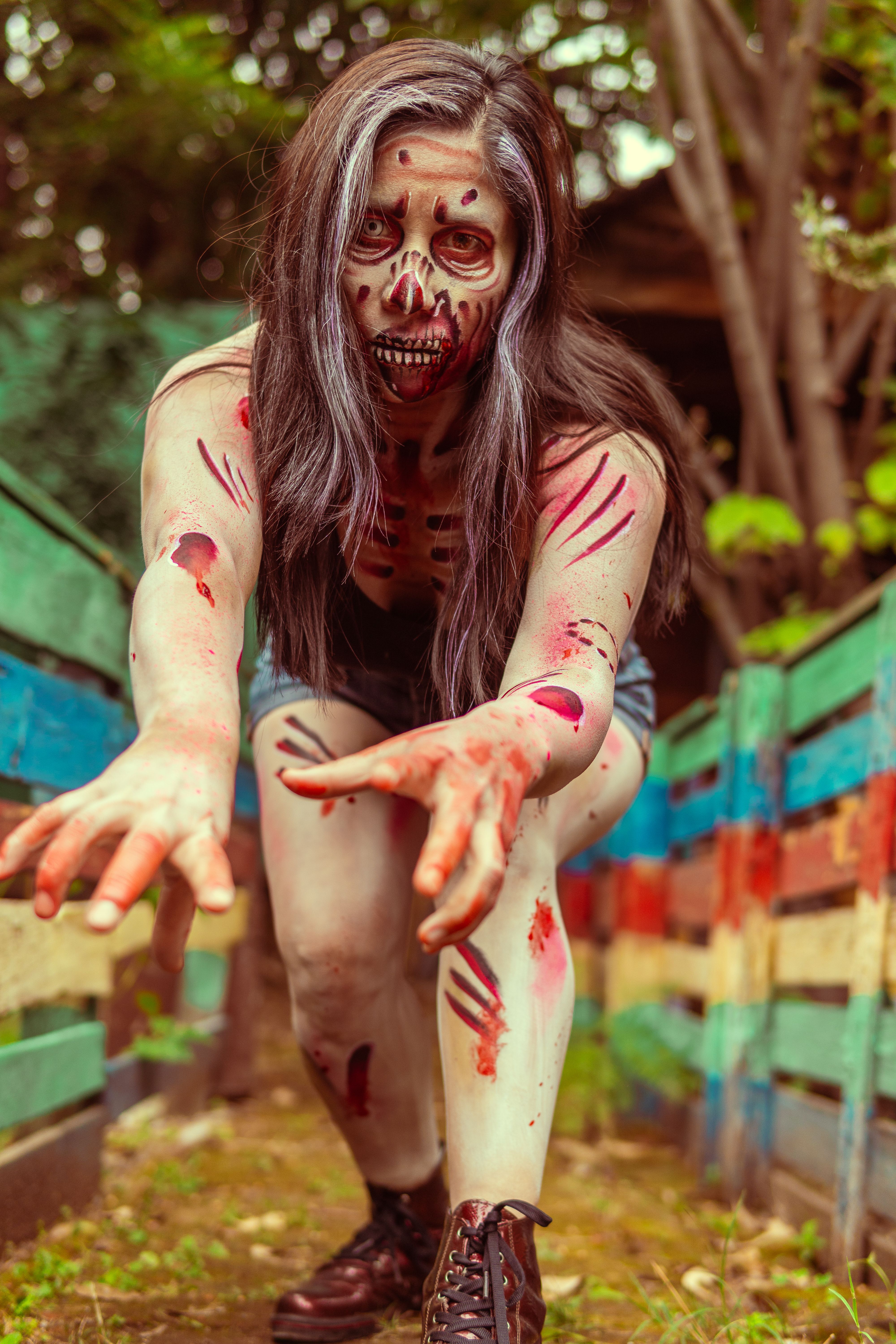 Detailed zombie makeup cosplay in a colorful outdoor setting, perfect for Halloween inspiration.