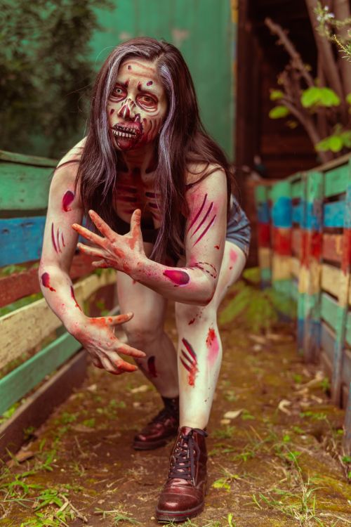 Free Woman in zombie cosplay outdoors with makeup and colorful setting, perfect for Halloween themes. Stock Photo