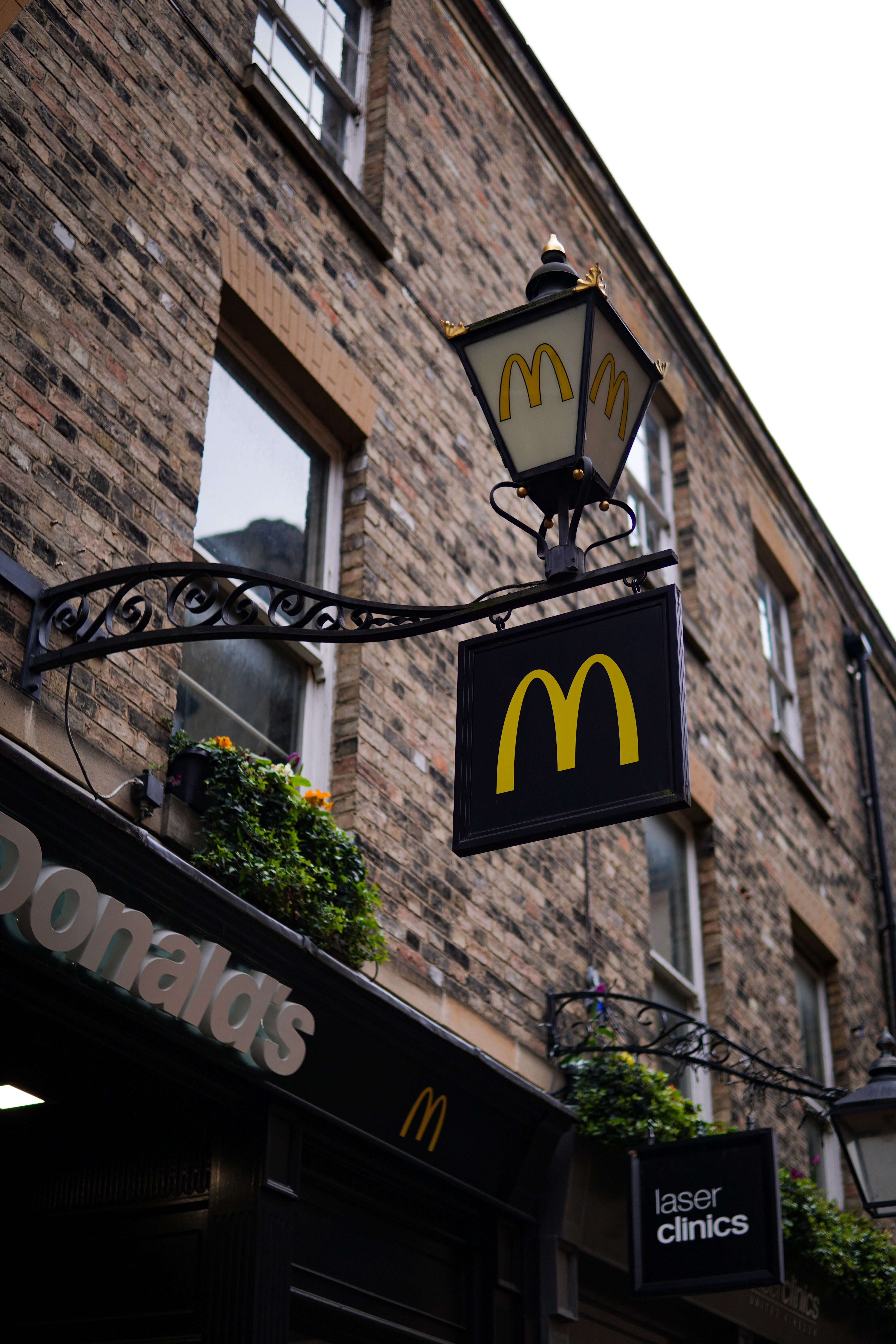 Classic McDonald's sign on a brick building in England's urban setting.