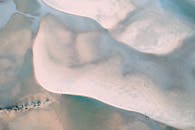 从空中俯瞰，沙质海岸呈现出海洋的图案，营造出宁静的沿海景观