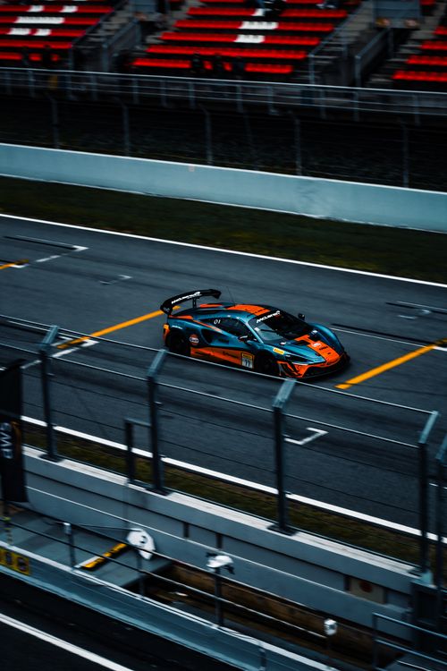 Free A luxury car at high speed on a race track in Spain. Aerial view with vibrant colors. Stock Photo