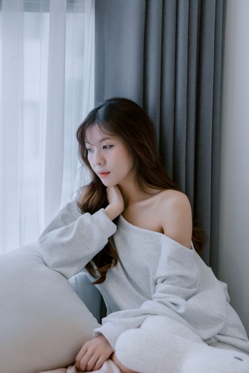 Woman with minimal gold jewelry over a grey loungewear set
