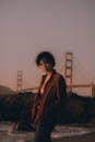 在旧金山，一个女人站在金门大桥上，欣赏着风景秀丽的日落
