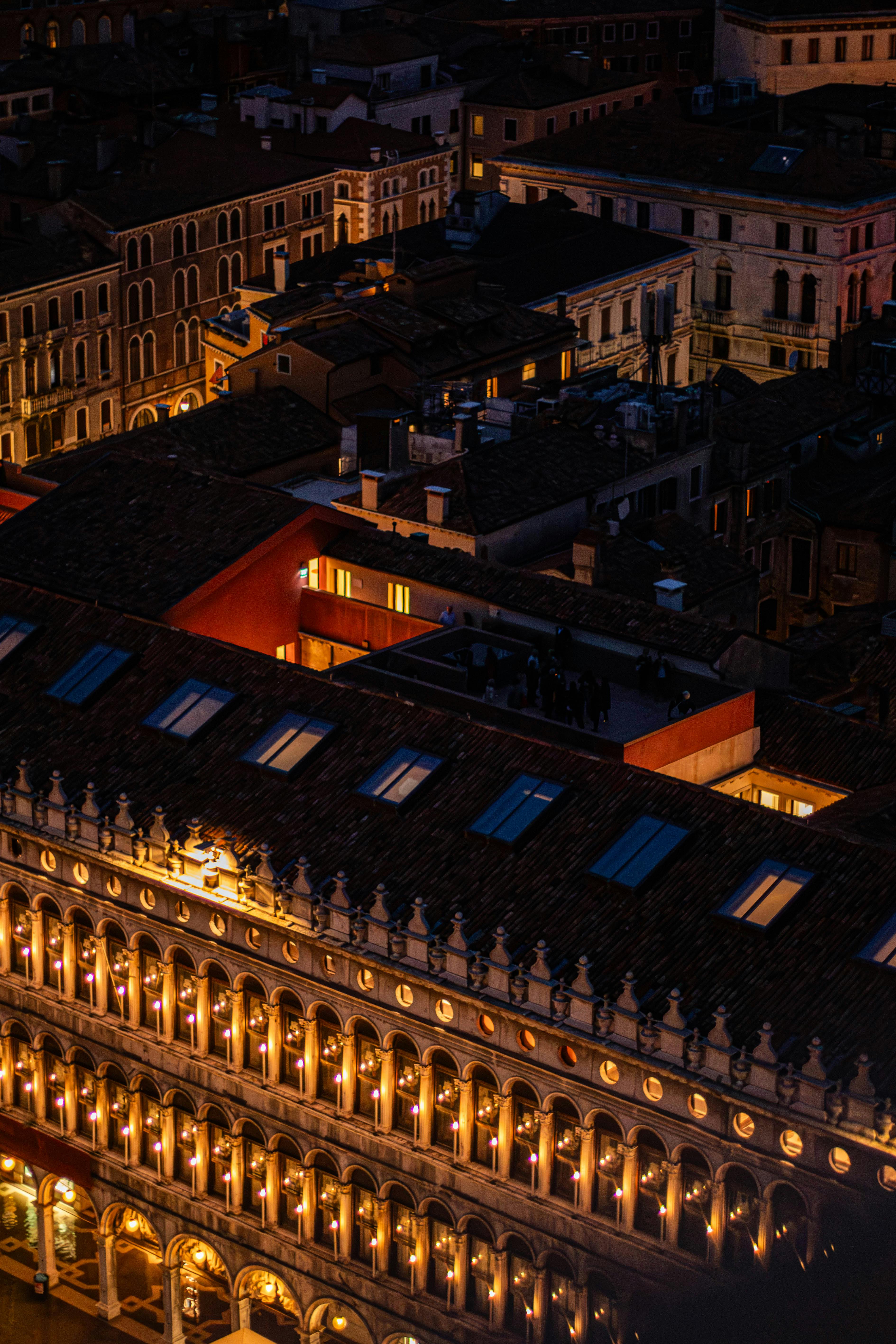 A stunning aerial view of Venetian architecture beautifully illuminated at night.