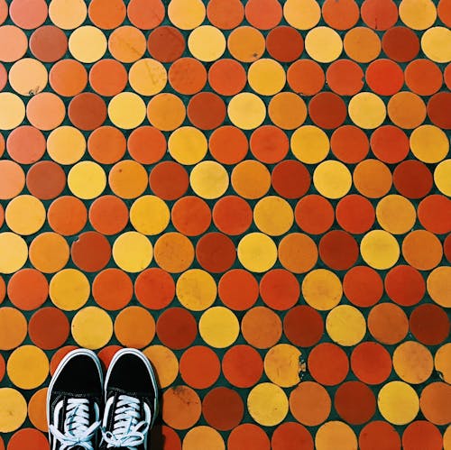 Photo of Black and White Shoes on a Floor with Circles
